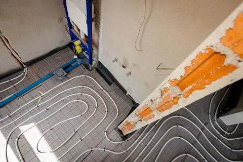 Pipe system of floor heating mounted in unfinished washroom Stock Photos