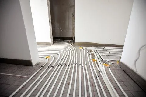 Pipe system of floor heating mounted in residential building under constructi Fotos de archivo