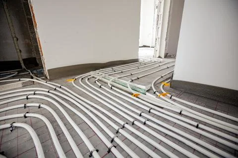 Pipe system of floor heating mounted in residential building under constructi Fotos de archivo