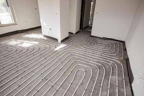 Pipe system of floor heating mounted in residential building under constructi Fotos de archivo