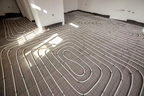 Pipe system of floor heating mounted in residential building under constructi Fotos de archivo