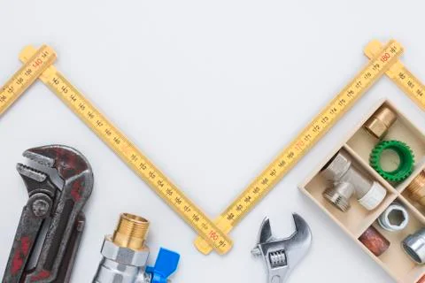 Pipe Wrench, Spanner, and Pipe Fittings with Zigzagging Folding Ruler Copy Sp Stock Photos