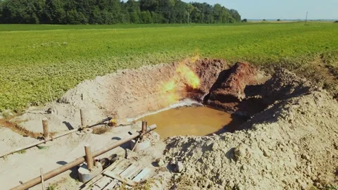 Pipeline construction with pit filled with substance near oil refinery. Burning Stock Footage 219953467