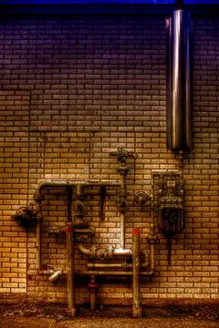 Pipes on brick wall Stock Photos