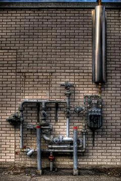 Pipes on brick wall Stock Photos