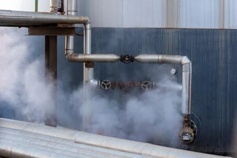 Pipes protected by their high temperature giving off steam. Stock Photos