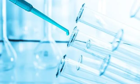 Pipette adding fluid to one of several test tubes .medical glassware Stock Photos