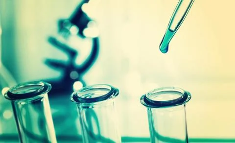 Pipette adding fluid to one of several test tubes .medical glassware Stock Photos