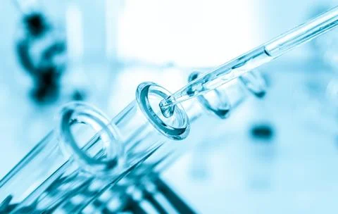 Pipette adding fluid to one of several test tubes .medical glassware Stock Photos