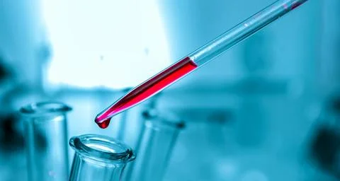 Pipette adding fluid to one of several test tubes .medical glassware. Stock Photos