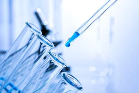 Pipette adding fluid to one of several test tubes .medical glassware. Stock Photos
