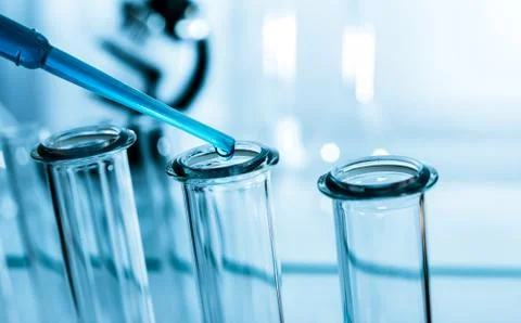 Pipette adding fluid to one of several test tubes .medical glassware. Foto stock