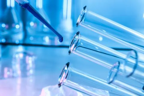 Pipette adding fluid to one of several test tubes .medical glassware. Stock Photos