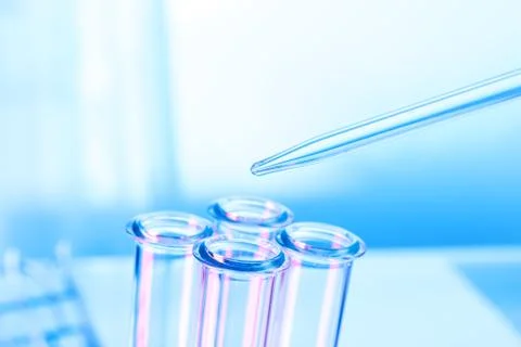 Pipette adding fluid to one of several test tubes . Stock Photos