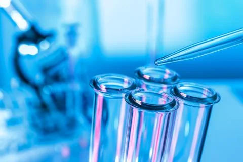 Pipette adding fluid to one of several test tubes . Stock Photos