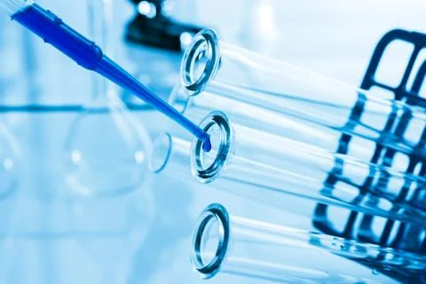 Pipette adding fluid to one of several test tubes . Stock Photos