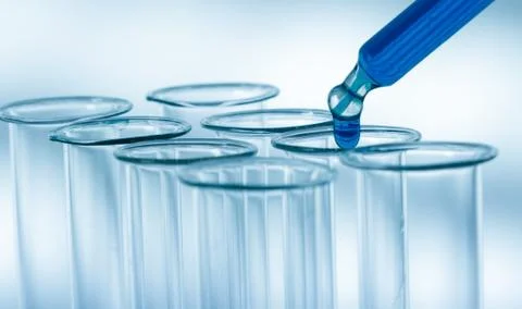 Pipette adding fluid to one of several test tubes .medical glassware Stock Photos