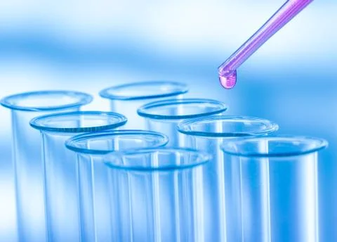 Pipette adding fluid to one of several test tubes .medical glassware Stock Photos