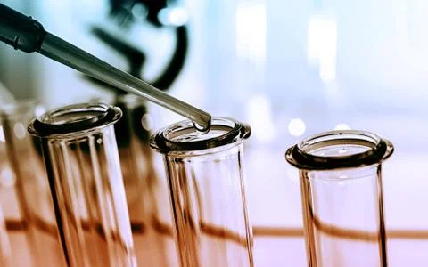 Pipette adding fluid to one of several test tubes .medical glassware. Stock Photos