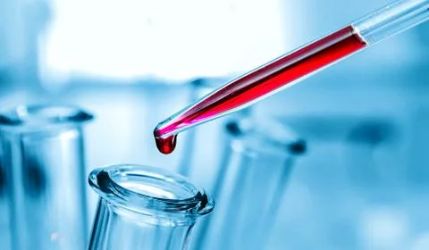 Pipette adding fluid to one of several test tubes . Stock Photos