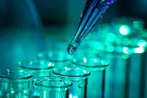 Pipette adding fluid to one of several test tubes Stock-Fotos