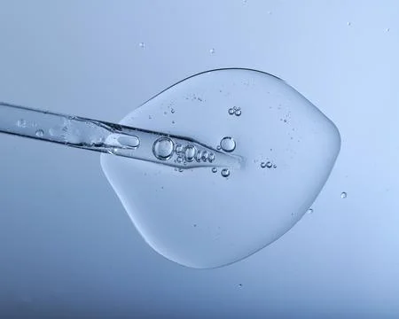 Pipette with bubbles and clear formulation being expelled. Stock Photos