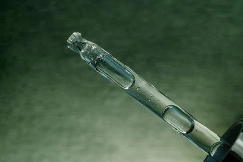 Pipette with bubbles on a green background. Foto stock