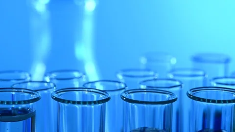 Pipette dropping sample into test tube blue light Stock Footage 121521366