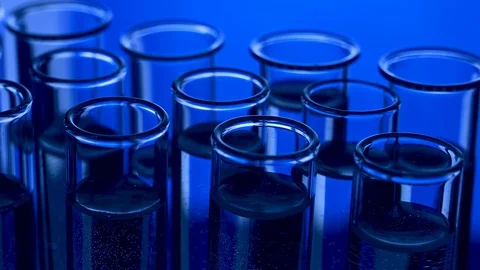 Pipette dropping sample into test tube blue light Stock Footage 121854636