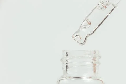 Pipette with a glass bottle on a light background. Stock Photos