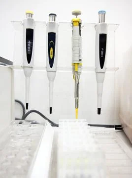 Pipettes hanging over the empty tubes 스톡 사진