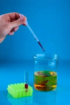 Pipetting into a beaker Stock Photos