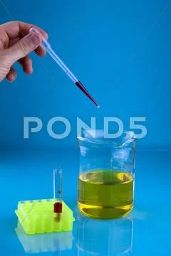 Pipetting into a beaker Stock Photos
