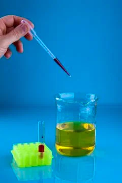 Pipetting into a beaker Stock Photos