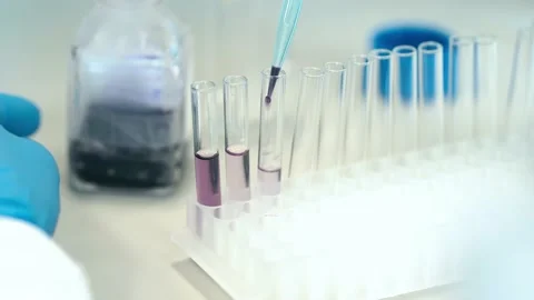 Pipetting a sample into a glass beaker during research in a scientific Stock Footage 239005874