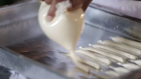 Piping cassava starch biscuits onto a baking tray, Natividade, Tocantins Stock Footage 317789544