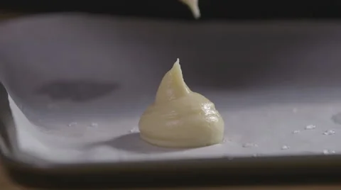 Piping choux pastry onto a baking tray Stock Footage 64026068