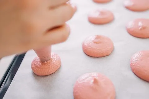 Piping Pink Macaron Batter Onto Baking Tray During Preparation Stock Photos