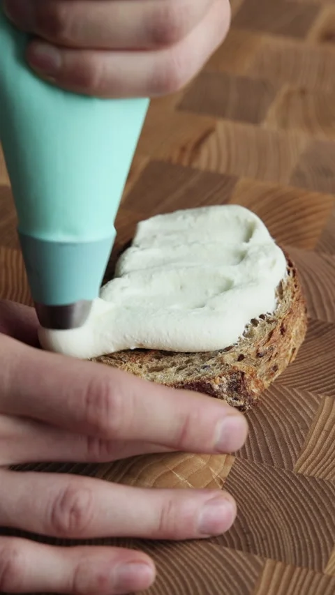 Piping Ricotta Onto Bread Close Up Stockbeeldmateriaal 334339397
