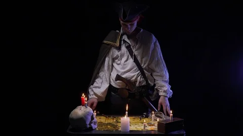 A pirate is looking at the treasure map with a magnifier and smokes a pipe, 4k Stock Footage 105398484