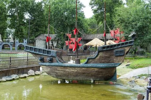 Pirate Ship Attraction at Theme Park Near Artificial Lake Фото