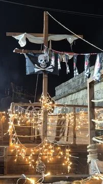 Pirate ship deck illuminated by string lights and pirate flags Stock Photos