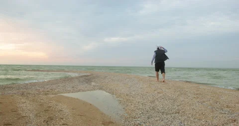 Pirate walks on beach with soft sand near sea at sunset Stock Footage 169977403