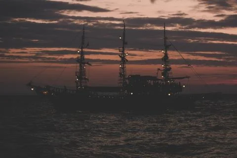 Pirates concept of soft focus old vintage ship silhouette on sea water surfac Stock Photos