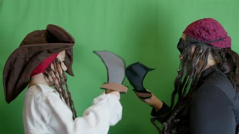 Pirates getting angry and fighting with cutlasses. Isolated on green background Stock Photos
