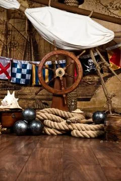 Pirates ship deck with steering wheel and flag Stock Photos