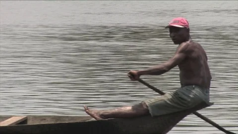Pirogue rower close up and man bathing, Wouri river Stock Footage 80478845
