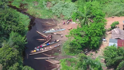 Pirogue at water's edge with people loading goods, top-down wide, Congo Stock Footage 332000153