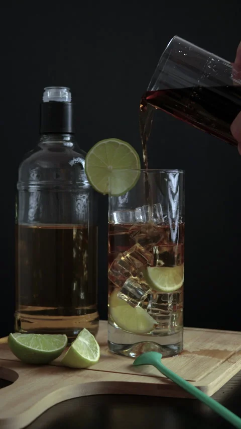 Piscola, preparing, cocktail, hand adding cola, glass with ice, wooden board, Stock Footage 262494571
