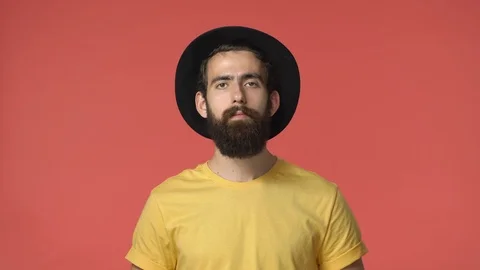 Pissed middle-eastern intense bearded man in black hat, yellow t-shirt clench Stock Footage 115779565